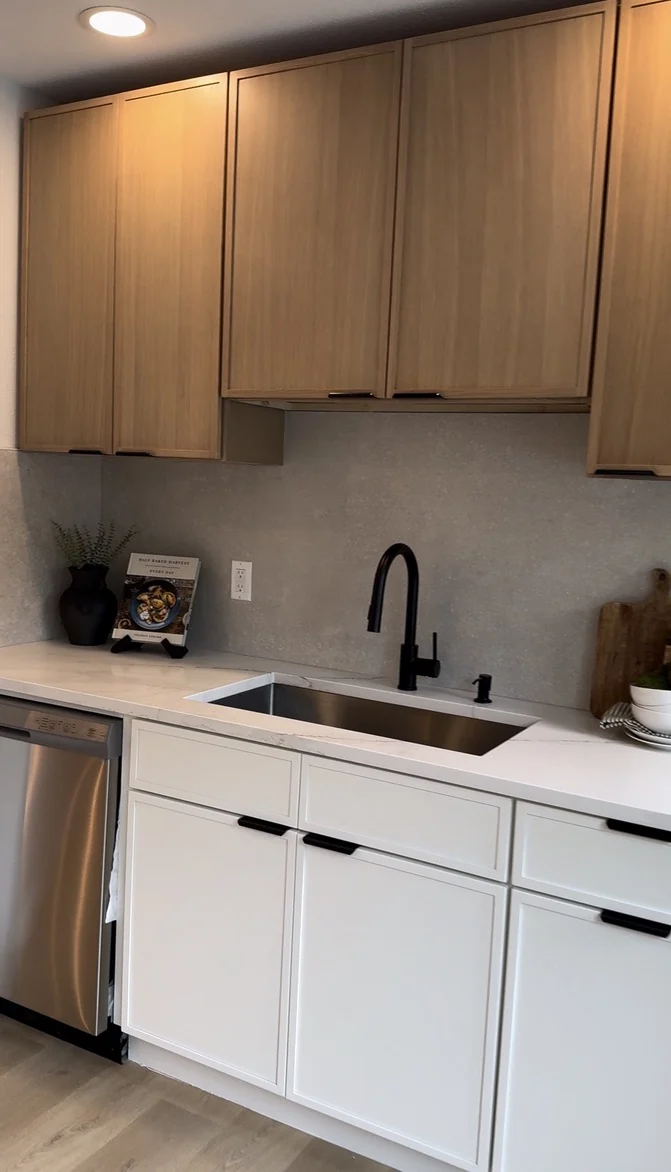 Completed two-tone kitchen sink wall with wood uppers and white base cabinets